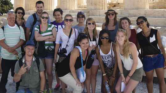 Students posing for the picture in front of Roman architecture on their Study Abroad trip