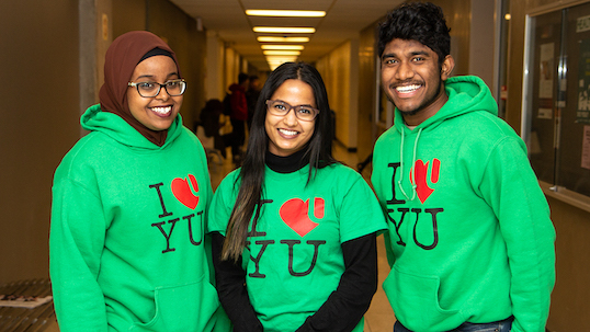 Three York students in green York hoodies smiling for the camera