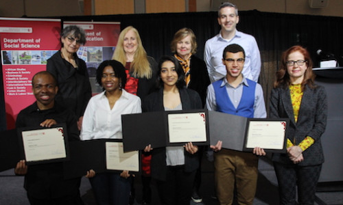 Students pose with their awards alongside professors