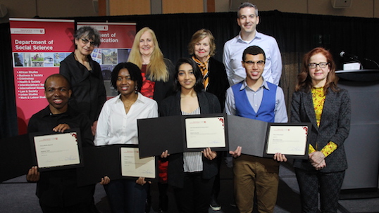 Students pose with their awards alongside professors