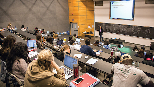 Lecture hall with students listening to a professor