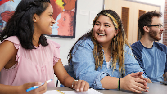 two students looking at each other and smiling