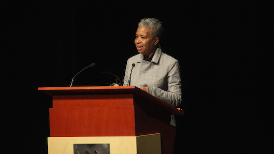 Author and poet Dionne Brand stands at podium while giving a lecture at York University