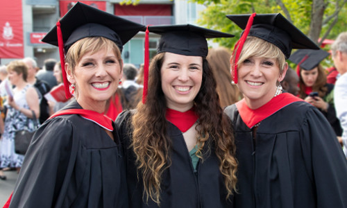 three smiling female grads on convocation
