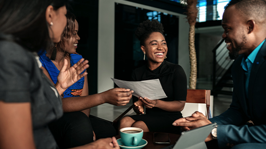 Black business colleagues discussing work while having coffee