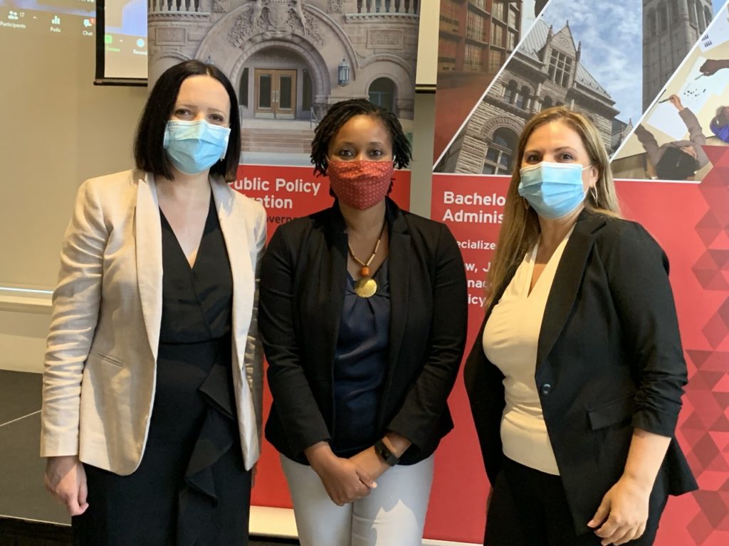 Three women pose for a photo in front of a banner for the SPPA event 