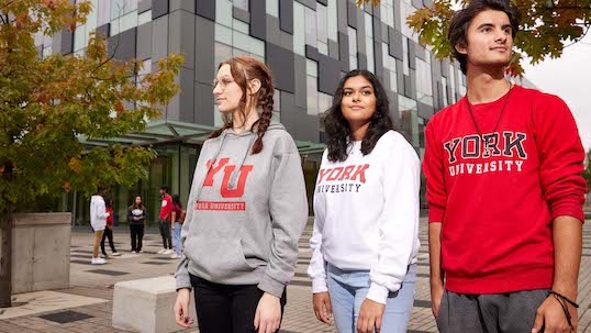 three students in front of building