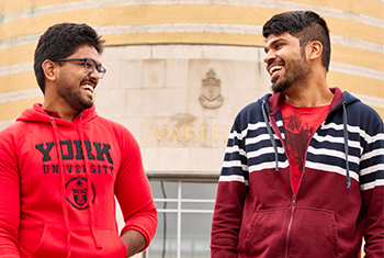 Two male students laughing on campus