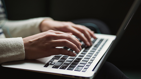 close up of person taking notes on computer