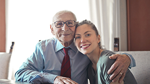 an elderly man embraces a young woman depicting the old and new generation