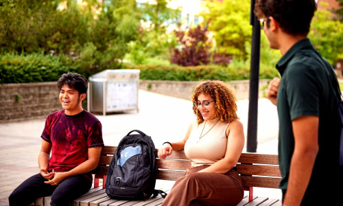 students sitting on bench on Keele Campus