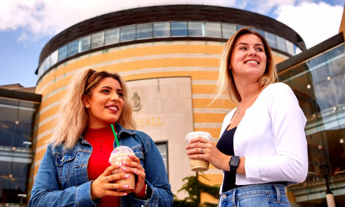 Two girls in front of vari hall doingcofee chat