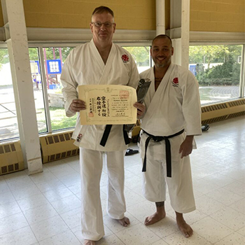 Phillips receiving black belt Shodan from Tsumura