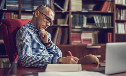 Male professor reviews his documents on a computer