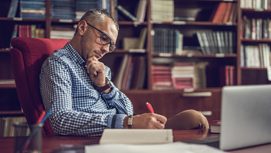 Male professor reviews his documents on a computer