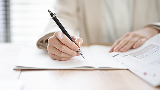 student writing homework on a table