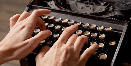 person typing on a typewriter machine