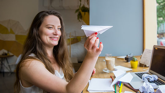 woman holding a paper plane