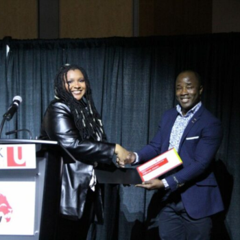 Mohamed Sesay posing with Zakirah Allain while presenting her with an award 