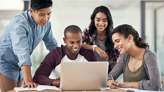 Shot of a group of young men and women using a laptop while studying together at University