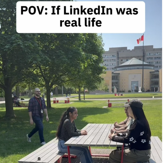 Participants sit around an outdoor picnic table on campus while on-screen text reads “POV: If LinkedIn was real life,” with campus buildings and green space in the background.