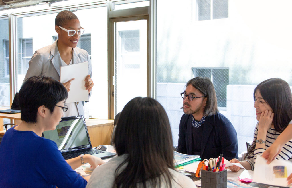 Diverse group of young adults working together with papers and laptop