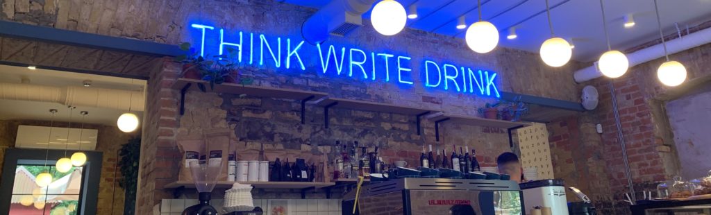 Image of bar with neon sign think, write, drink