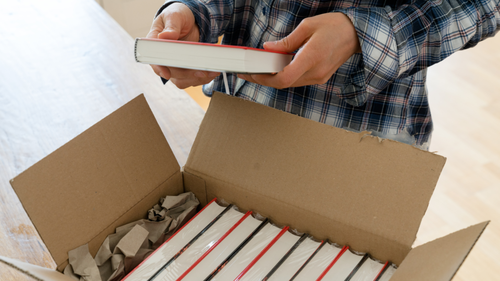 A person opens a box of books