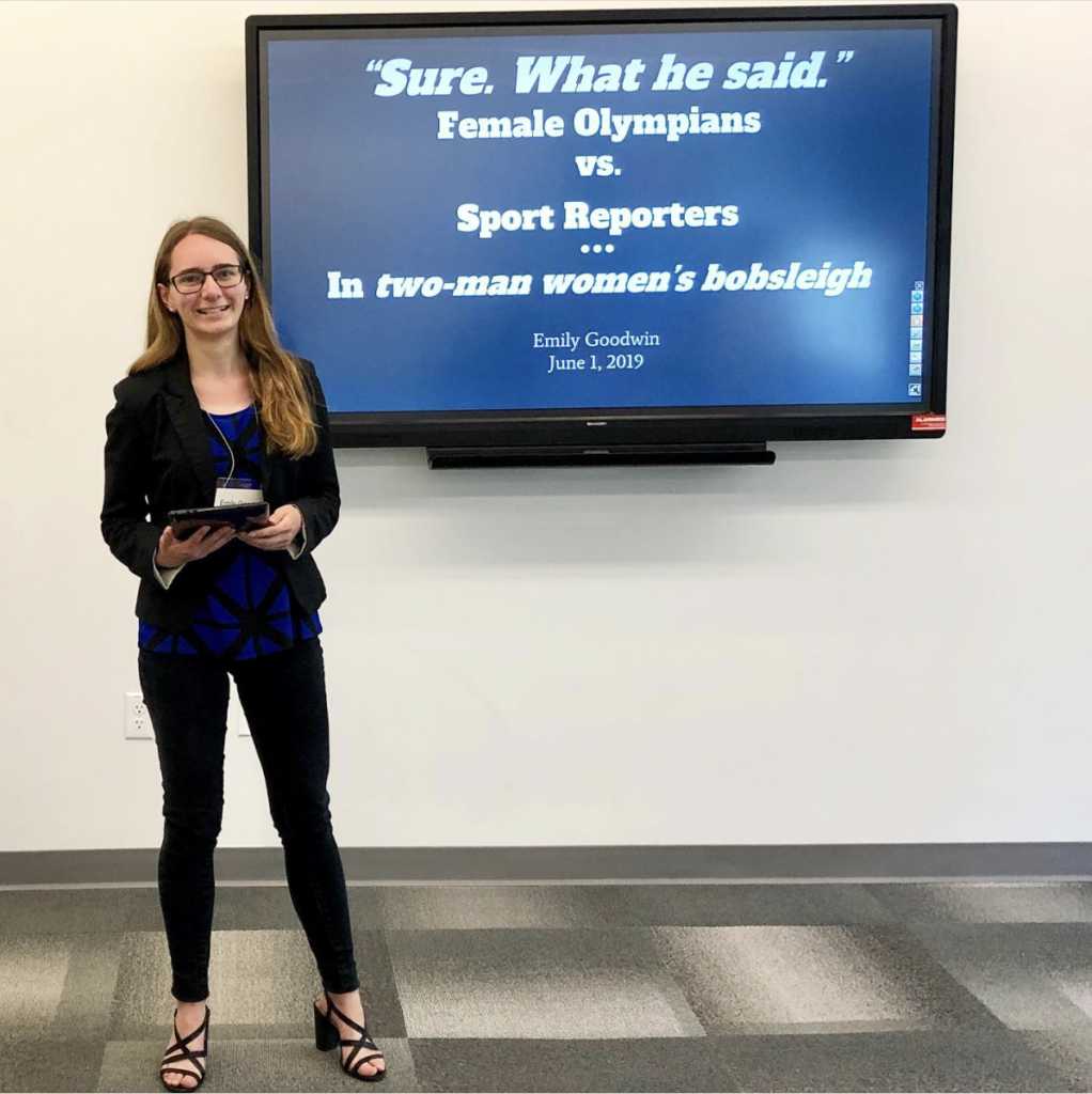 Emily Goodwin stands in front of her presentation slides at the CASDW 2019 conference