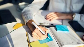 close up of person taking notes in notebook