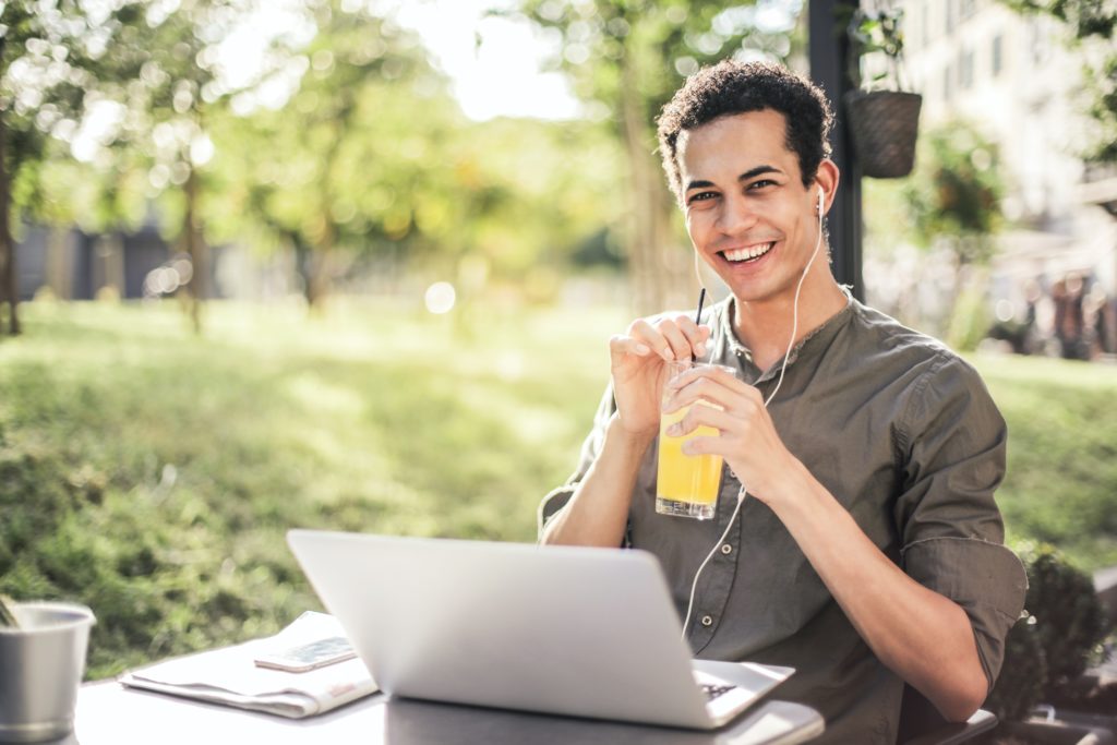 Man smiling while using his laptop