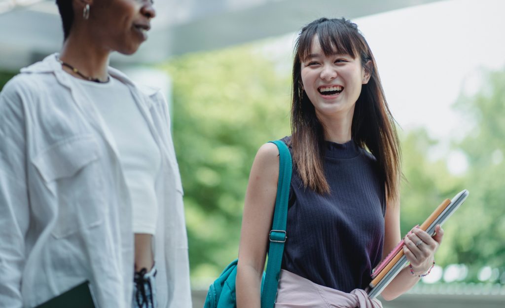 Student smiling while carrying books