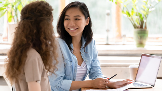 Two females studying on a laptop.