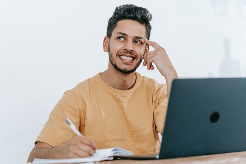 Male student smiling while thinking to the side