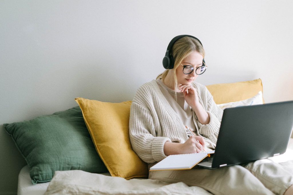 Girl using her laptop while listening to headphones