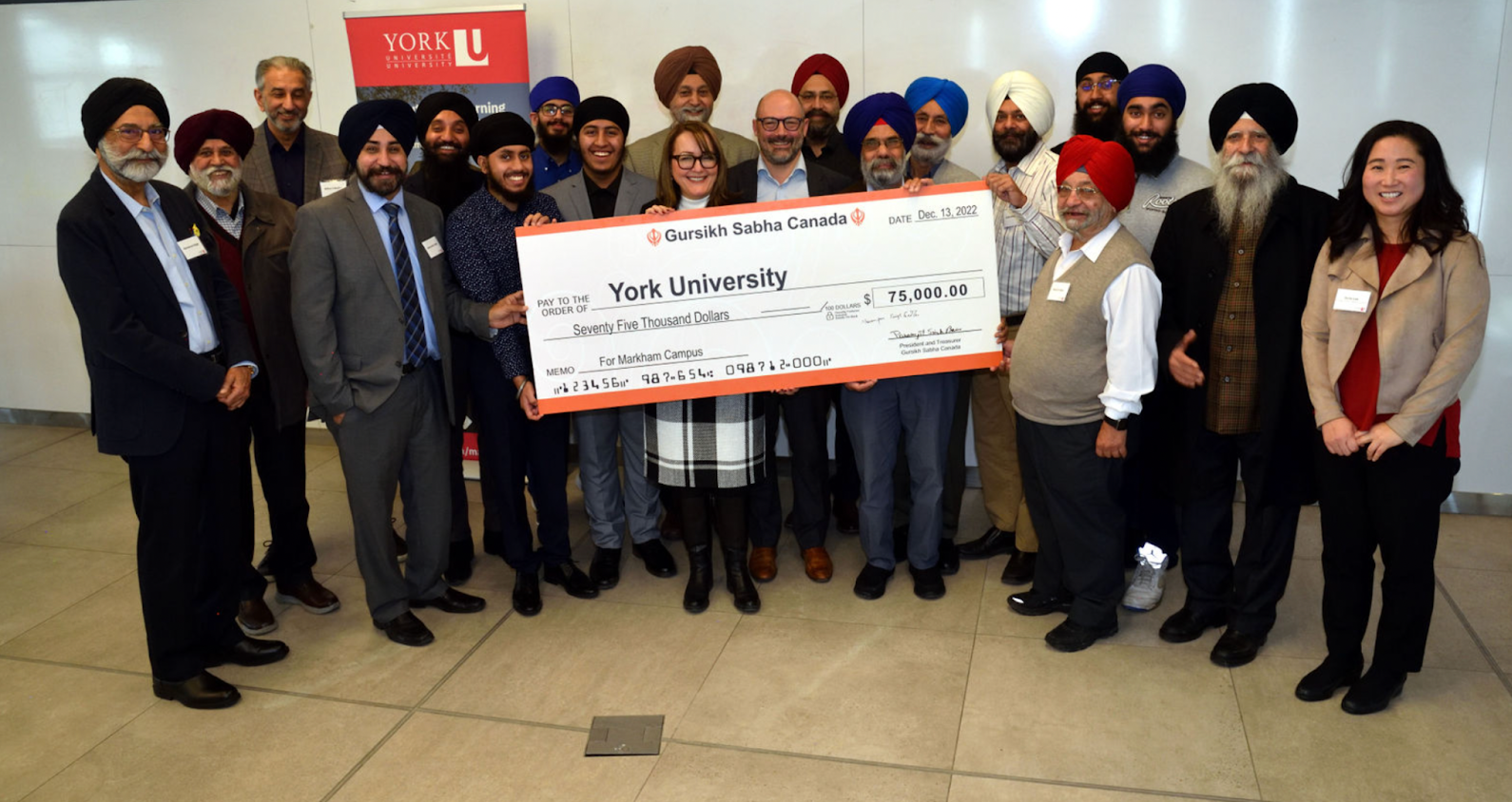 York University staff and members of York Sikh Students Association and Gursikh Sabha Canada pose for a picture presenting Gursikh Sabha's cheque to the University.