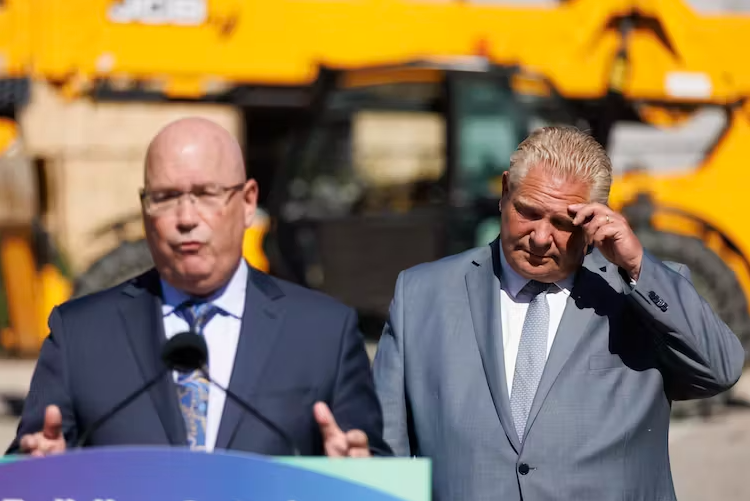 Ontario Premier Doug Ford listens as Steve Clark, then the housing minister, speaks during a news conference in Mississauga.