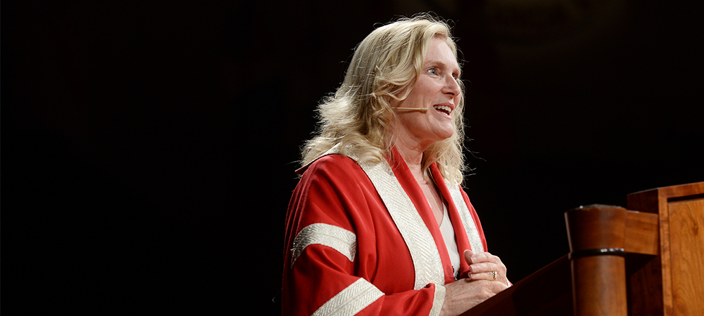 Photo of President Lenton in convocation robe at lectern, speaking