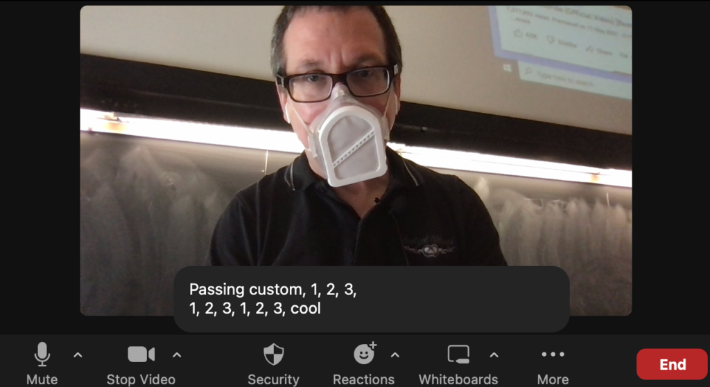 Man in a respirator over zoom from a classroom, with the captioned text that says "passing custom, 1, 2, 3, 1, 2, 3, 1, 2 3, cool"