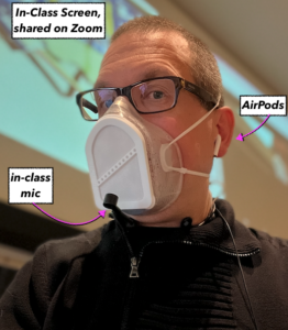 Man wearing a mask and AirPods and a wireless Shure microphone.