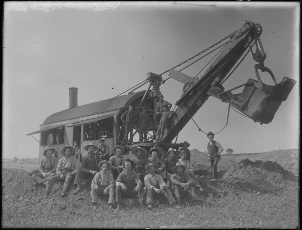 Workers posing around a steam shovel on the Grand Trunk Pacific railroad construction project.