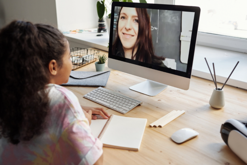 A girl video calling a woman on computer.