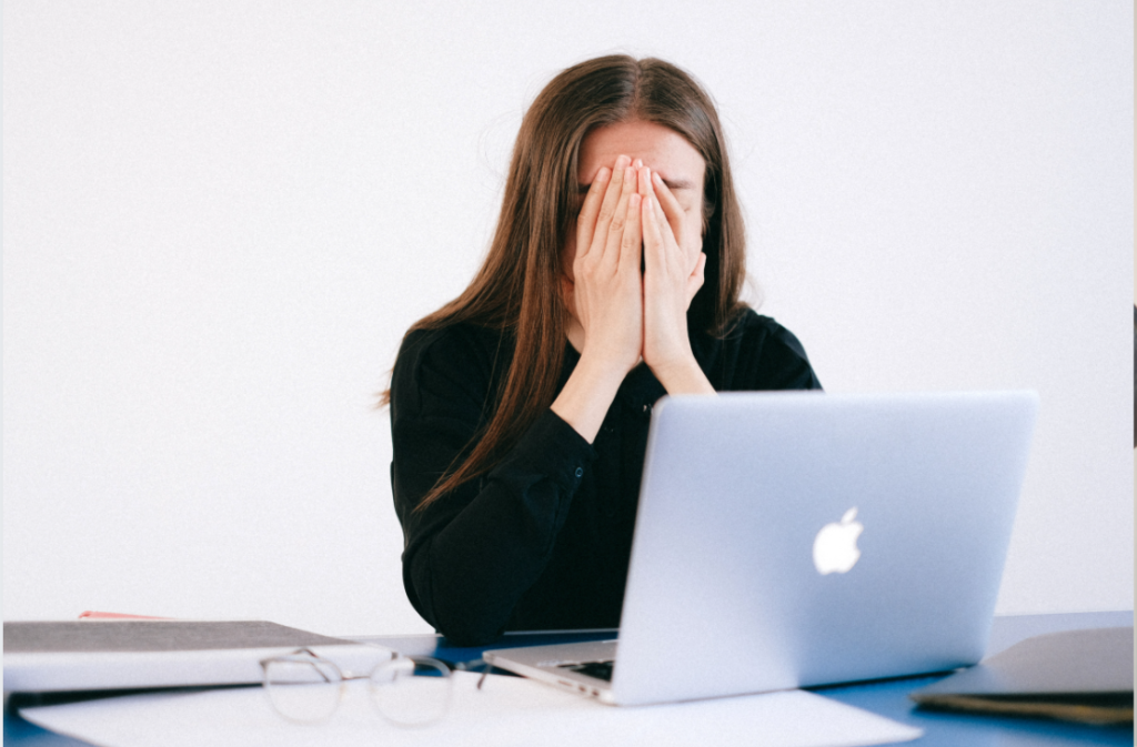 A tired woman in front of a laptop.