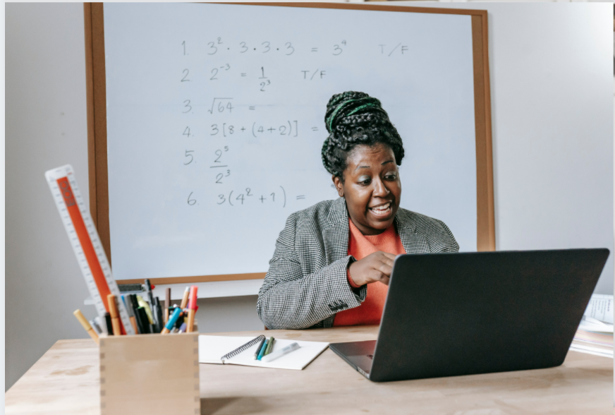 A woman in a meeting using her laptop.