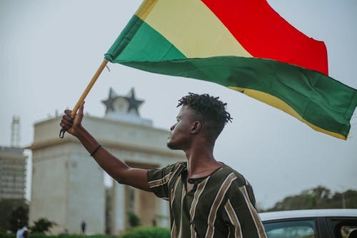 A boy holding ghana flag.