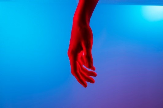 A red hand with blue background.