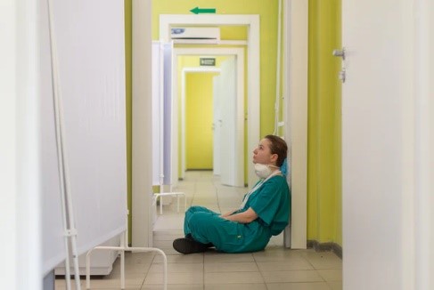 A tired nurse sitting in the hallway