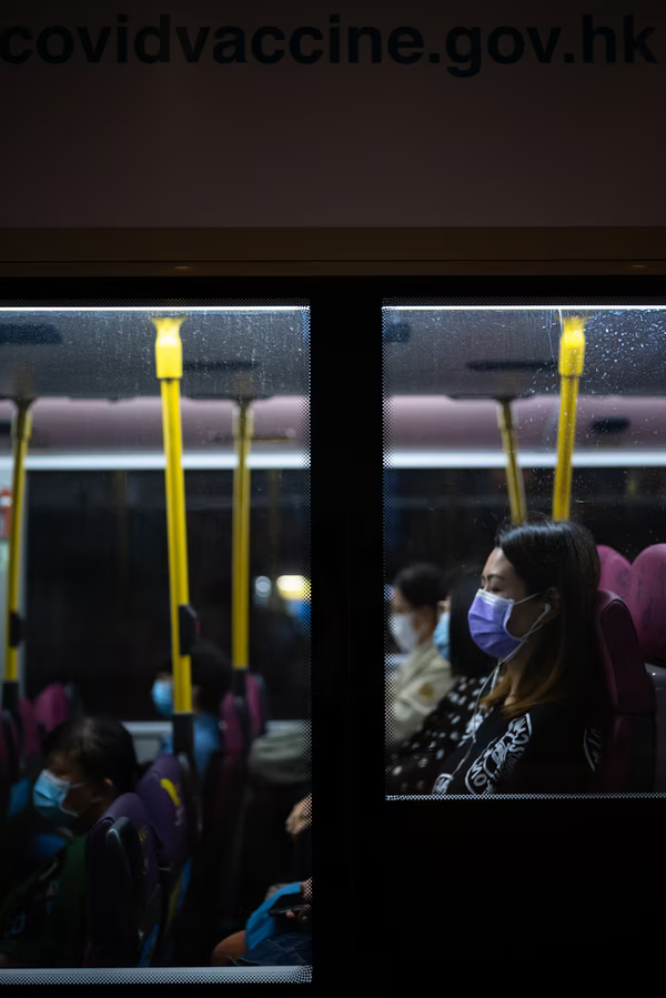 A woman in bus with mask on.