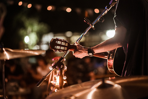 A person playing the guitar at night.