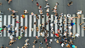 A crowd of people crossing a crosswalk, overhead shot. 